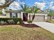 A charming home showcases a well-manicured lawn, complemented by beautiful landscaping and a two-car garage at 1568 Brandywine Dr, Tavares, FL 32778