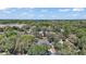 Expansive aerial view of lushly landscaped home, surrounded by mature trees and nature, with a lake in the background at 15803 Fairview Pt, Tavares, FL 32778