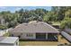 Back exterior of home with a screened-in porch and well-maintained lawn, offering a peaceful outdoor living space at 15803 Fairview Pt, Tavares, FL 32778