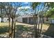 View of backyard with a home's screened-in patio and a storage shed from a rock garden at 15803 Fairview Pt, Tavares, FL 32778