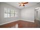 Neutral bedroom with hardwood floors, ceiling fan, and natural light at 15803 Fairview Pt, Tavares, FL 32778