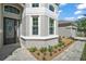 Home exterior featuring meticulously landscaped front yard with brick walkway, mature plantings, and gray stucco at 15803 Fairview Pt, Tavares, FL 32778