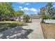 Well-manicured front exterior of a charming single-Gathering home, complemented by a long driveway and a two-car garage at 15803 Fairview Pt, Tavares, FL 32778