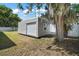 Durable shed with roll-up door and window, nestled near a mature, moss-draped tree at 15803 Fairview Pt, Tavares, FL 32778