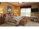 Cozy bedroom with a wicker bed frame, a view of the outside, and a tv at 1721 Carrera Dr, The Villages, FL 32159