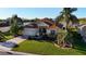 Beautiful one-story home with a well-manicured lawn and mature palm trees near the lake at 1721 Carrera Dr, The Villages, FL 32159