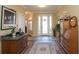 Welcoming foyer with tile and hardwood floors, decorative glass door, and ample natural light at 1721 Carrera Dr, The Villages, FL 32159