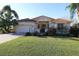 Charming single-story home with well-manicured lawn, mature landscaping, and inviting entrance at 1721 Carrera Dr, The Villages, FL 32159