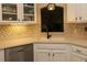 Bright kitchen featuring white cabinets, mosaic backsplash, stainless steel dishwasher, and under cabinet lighting at 1721 Carrera Dr, The Villages, FL 32159