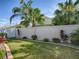 A serene fenced backyard features lush green grass, tropical plants, and a well-manicured landscape at 1829 Foxwood Ln, The Villages, FL 32162