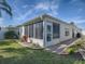 Backyard with a screened lanai, meticulous landscaping with a stone bed, and walkway at 1829 Foxwood Ln, The Villages, FL 32162