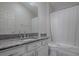 Clean bathroom featuring a granite countertop, white cabinets, and shower with tub at 1829 Foxwood Ln, The Villages, FL 32162