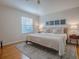 Serene bedroom with a large bed, stylish rug, and natural light from the window at 1829 Foxwood Ln, The Villages, FL 32162