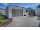 Charming home featuring white siding, a paved driveway, and a screened garage at 1829 Foxwood Ln, The Villages, FL 32162