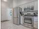 Kitchen with stainless steel appliances including refrigerator, range, and microwave, adjacent to the entryway at 1829 Foxwood Ln, The Villages, FL 32162