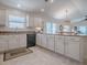 Bright kitchen featuring white cabinets, stainless appliances, and breakfast bar with an open view to the living room at 1829 Foxwood Ln, The Villages, FL 32162