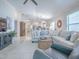 Spacious living room with an open layout featuring a sectional sofa, tile flooring, and access to other living spaces at 1829 Foxwood Ln, The Villages, FL 32162