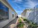 Exterior side yard with a garden bed, and patio at 1829 Foxwood Ln, The Villages, FL 32162