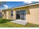 Backyard with a concrete patio, sliding glass door, lush green grass, and a well-maintained exterior at 202 Compass Rose Dr, Groveland, FL 34736