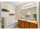 Bright bathroom featuring a double vanity, a soaking tub, and modern fixtures at 202 Compass Rose Dr, Groveland, FL 34736