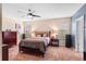 A cozy bedroom has carpet flooring, a ceiling fan, and natural light from the window at 202 Compass Rose Dr, Groveland, FL 34736