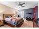 A bedroom has carpet, ceiling fan, and a modern headboard and minimalist decor at 202 Compass Rose Dr, Groveland, FL 34736