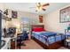 Cozy bedroom features a bed, desk, ceiling fan and natural light from the window at 202 Compass Rose Dr, Groveland, FL 34736