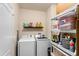 Functional laundry room equipped with a washer, dryer, and storage shelving at 202 Compass Rose Dr, Groveland, FL 34736