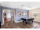 Open-concept living room featuring an air hockey table and wood laminate flooring at 202 Compass Rose Dr, Groveland, FL 34736