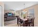 Open-concept living and dining area features tile floors, a ceiling fan, and sliding glass doors at 202 Compass Rose Dr, Groveland, FL 34736