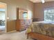 Bright bedroom featuring a large dresser and view to a living area through an open door at 2523 Mariel Way, The Villages, FL 32162