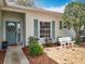 Close-up view of a home's entrance featuring a teal door, sidelights, and lovely landscaping at 25239 River Crest Dr, Leesburg, FL 34748