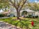 Well-manicured front yard with a charming single-story home shaded by mature trees at 25239 River Crest Dr, Leesburg, FL 34748