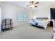 Spacious main bedroom with a ceiling fan, plush carpet, and large window for natural light at 25239 River Crest Dr, Leesburg, FL 34748