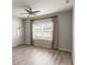 Bright living room featuring light gray walls, wood-look floors, a ceiling fan, and a large window with backyard view at 3341 Winchester Estates Cir, Lakeland, FL 33810