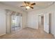 Primary bedroom with neutral carpet, ceiling fan, access to screened in lanai, and en suite bathroom at 3341 Winchester Estates Cir, Lakeland, FL 33810