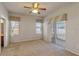 Primary bedroom with neutral carpet, ceiling fan, windows and access to screened in lanai at 3341 Winchester Estates Cir, Lakeland, FL 33810