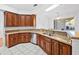 Kitchen with granite counters, stainless steel sink, and wood cabinets at 5953 Sailboat Ave, Tavares, FL 32778