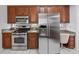 Kitchen with stainless steel refrigerator, stainless steel stove, and wood cabinets at 5953 Sailboat Ave, Tavares, FL 32778