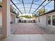 An enclosed patio featuring light colored pavers, white walls, light landscaping, and a black metal frame at 5953 Sailboat Ave, Tavares, FL 32778