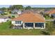 Aerial view of the sunroom highlighting the furnishings, verdant lawn and beautifully landscaped yard at 6126 Mulligan Run, The Villages, FL 32163