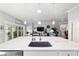 A kitchen island with a marble countertop and stainless steel appliances overlooks the open living area at 6126 Mulligan Run, The Villages, FL 32163