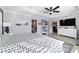 Spacious main bedroom featuring tray ceiling, ceiling fan, wood look tile floors, and ensuite bathroom and walk-in closet at 6126 Mulligan Run, The Villages, FL 32163