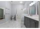 Bright bathroom with a double vanity, modern fixtures, marble floors, and a glass shower at 6200 Topsail Rd, Lady Lake, FL 32159