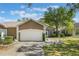 Charming single-story home with a two-car garage, a well-maintained lawn, and beautiful landscaping at 6200 Topsail Rd, Lady Lake, FL 32159