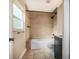 Bathroom featuring stone tile, shower with black hardware, a sink, and a window at 7549 Frog Log Ln, Leesburg, FL 34748