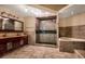 Luxurious bathroom with double vanities, a glass-enclosed shower, and soaking tub at 7549 Frog Log Ln, Leesburg, FL 34748