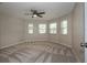 An airy bedroom featuring neutral walls, multiple windows, and a ceiling fan with light at 7549 Frog Log Ln, Leesburg, FL 34748