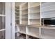 A walk-in pantry featuring wooden countertops, a microwave, and white shelving at 7549 Frog Log Ln, Leesburg, FL 34748