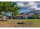 Back exterior view showcasing a large yard and fire pit at 7549 Frog Log Ln, Leesburg, FL 34748